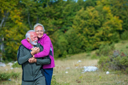 Happy senior couple smiling outdoors in nature. Grandparents, autumn.の写真素材