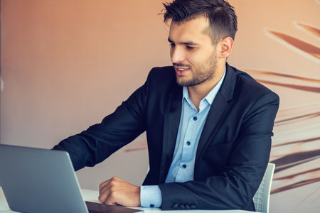 Handsome smiling bearded clerk man at office workplace with silver pen in arms do paperwork portrait. Staff dress code worker job offer client visit study profession boss market idea coach training.の写真素材