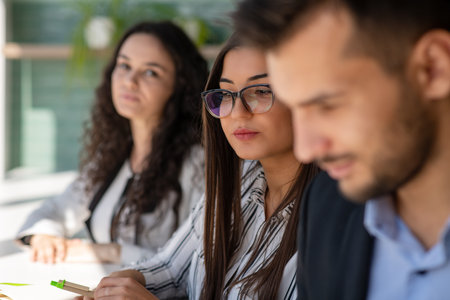 Creative business team sharing laptop in office, watching startup presentation, brainstorming, pointing at monitor, talking.の写真素材