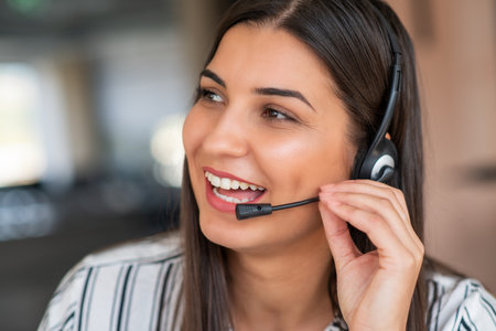 Young friendly operator woman agent with headsets working in a call centre.の写真素材