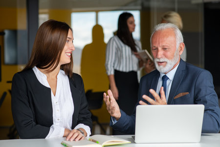 Mature businessman leader mentor talking to diverse colleagues team listening to caucasian ceo.の写真素材