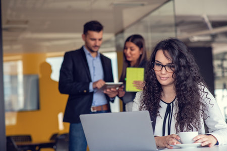 Confident attractive young business woman with tablet in hands in modern office start up officeの写真素材