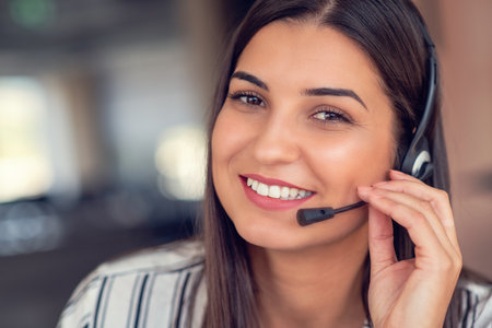 Young friendly operator woman agent with headsets working in a call centre.の写真素材