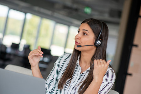 Brunette Lady Video Calling On Laptop Wearing Headphones Smiling And Waving Hand To Webcam Communicating Onlineの写真素材