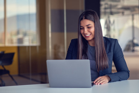 Portrait of beautiful businesswoman working with laptop at office. Business concept. Portrait of modern successful female leaderの写真素材