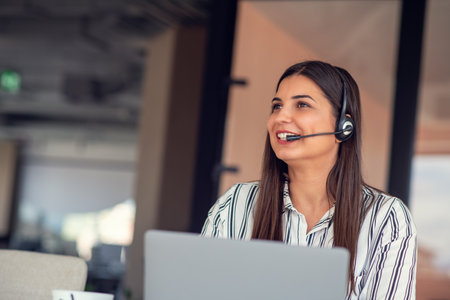 Young friendly operator woman agent with headsets working in a call centre.の写真素材