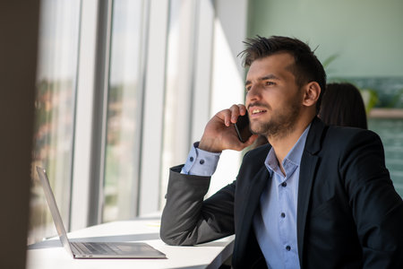 Young businessman talking on the phone at the officeの写真素材