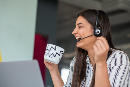 Young friendly operator woman agent with headsets working in a call centre.の写真素材