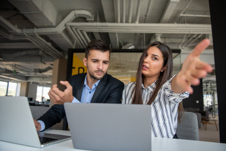 Young latin couple working using laptop sitting on the table at home.の写真素材