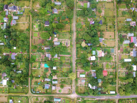 Multiple allotment gardens with little arbors, greenhouses, trees and bushes, aerial view.の写真素材