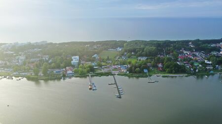 Drone Aerial Perspective View on Touristic City Located on narrow Spit between Sea and Lake with...