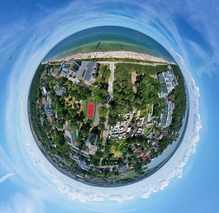 Drone aerial panoramic 360 degree view on sunny beach with sunbathers with windbreaks and towels at...