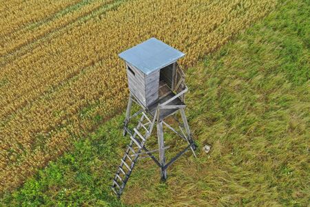 Perspective aerial drone view on wooden hunting tower in fields and meadows surroundingsの写真素材