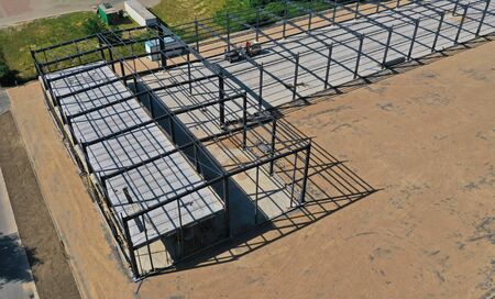 Aerial drone perspective view on steel construction frame, on building site, concrete floor with...