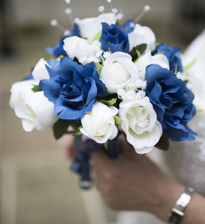 Close up of a blue and white wedding bouquet held by brideの写真素材