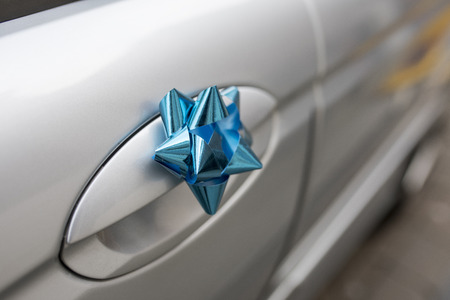 Close up of a blue wedding bow on the handle of a silver wedding carの写真素材