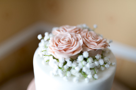 Close up of a pink icing fondant rose petals with babies breath decoration on top of a beautiful wedding cake in the UKの写真素材