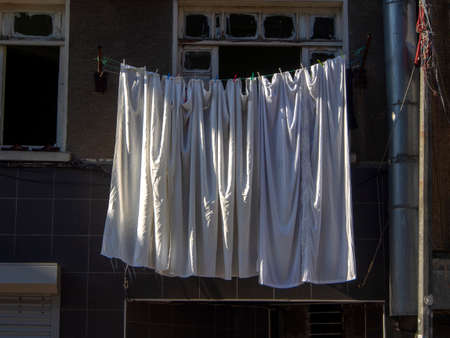 white clothes hanging on a rope in the street