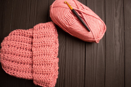 pink yarn and warm crochet yarn hat for crocheting on a dark table.の写真素材