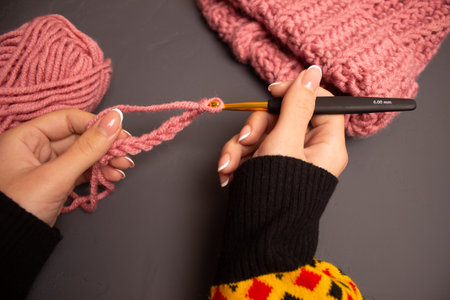 girl knit winter things from pink yarn with gold crochet.