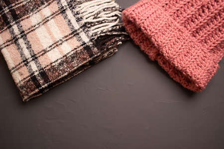 warm bright checkered scarf and knitted hat on a gray backgroundの写真素材