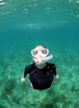 Woman with snorkel and dive mask snorkeling underwater in oceanの写真素材