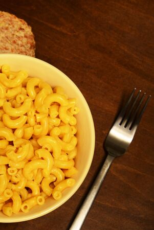 mac and cheese for meal with fork on wooden table の写真素材