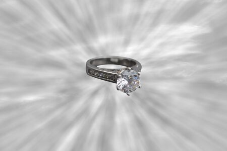 An engagement ring or wedding ring in the middle of a sun rays の写真素材