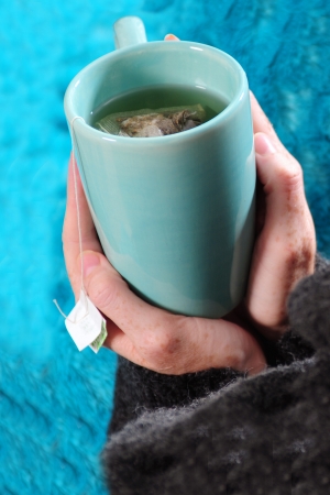 drinking tea in winter with blue mug and blanketの写真素材