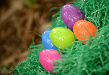 plastic easter eggs in fake green grassの写真素材