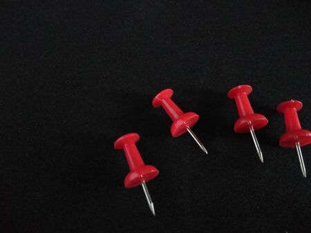 red push pins on black background