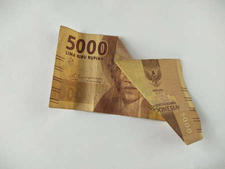 Indonesian paper money on white background.IDR cash currency,old, folded banknotes, business concept