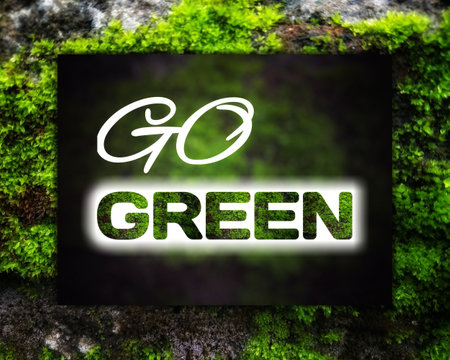 Go green text with natural green texture on blurred green background with dark vignette.go green conceptの写真素材