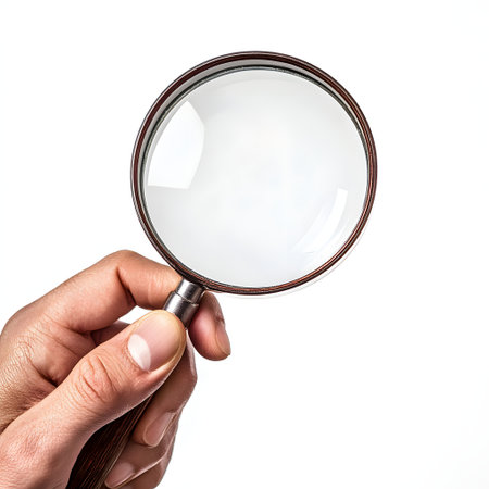 Magnifying glass in hand isolated on white background. Close up.の素材