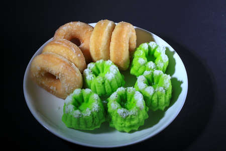 Donut and Kuih Seri Ayu are serve on white plate - Malaysian Traditional cakesの写真素材
