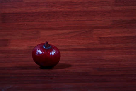 Red onions isolated on wooden background. Red onions are cultivars of the onion with purplish-red skin and white flesh tinged with red. They are most commonly used in the culinary arts,の写真素材