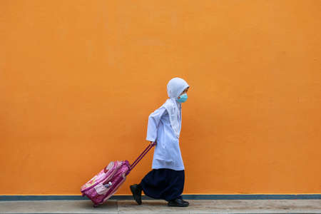 Kedah/Malaysia-September 9 2020: Students wearing face masks following restrictions to halt the spread of the COVID-19 at Primary School in Alor Setar Kedah.のeditorial素材