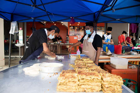 Alor Setar Kedah,MALAYSIA- May 3 ,2020: A hawker vendor wearing protective mask during covid 19. Food vendor cooking famous Malaysian food called martabak at open bazar.のeditorial素材