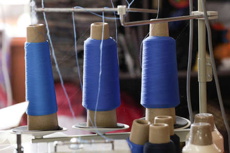 Colorful embroidery thread spool using in garment industry, row of multicolored yarn rolls, sewing material selling in the marketの写真素材