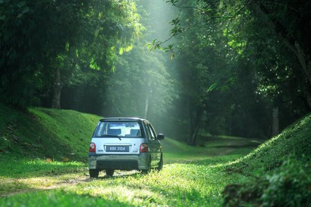 Sintok, Kedah Malaysia - 12 Sept 2020 : Sun ray in forest with car, Ray of light in in green forest with carのeditorial素材