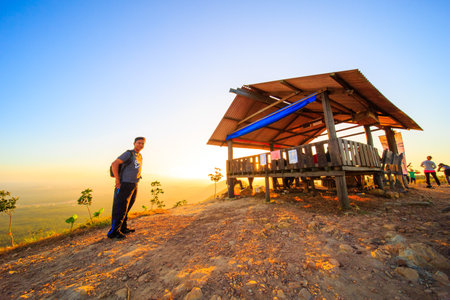 kedah, Malaysia - December 13, 2019: beautiful scenery in the morning and starburst sunrise at Bukit Laka, changlun with a groups of hikerのeditorial素材