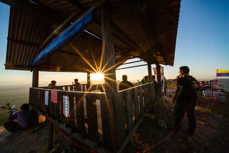 kedah, Malaysia - December 13, 2019: beautiful scenery in the morning and starburst sunrise at Bukit Laka, changlun with a groups of hikerのeditorial素材