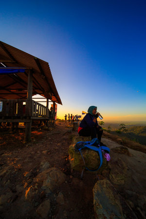kedah, Malaysia - December 13, 2019: Hiker enjoying nature on top of mountain with sunrise, many residents around Bukit Laka, Changlun climb the hill to see the beautiful scenery in the morningのeditorial素材