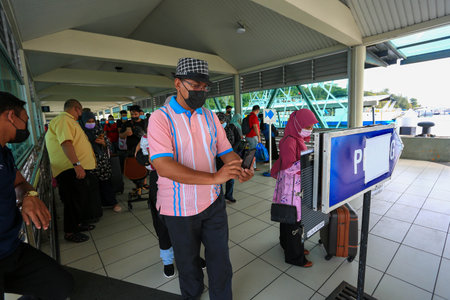 LANGKAWI,KEDAH-DECEMBER 23 2020: Crowd of unrecognizable local tourist wearing surgical mask for...