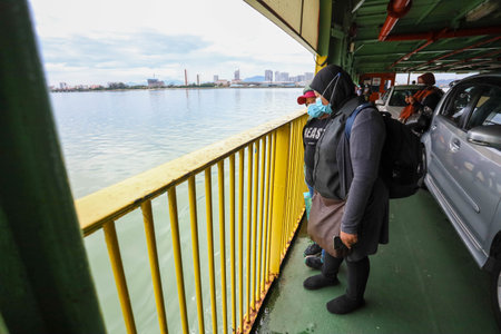Pulau Pinang , Malaysia - Dec 19 2020: Crowd of unrecognizable local tourist wearing surgical mask for prevent coronavirus Outbreak at Butterworth ferry terminal to Penang islandのeditorial素材