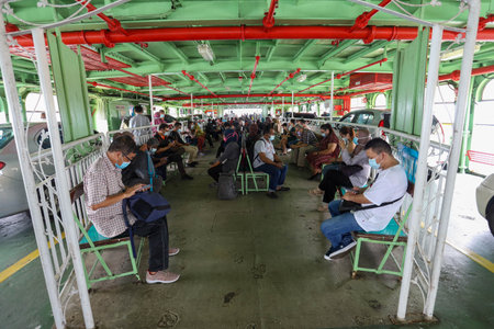 Pulau Pinang , Malaysia - Dec 19 2020: Crowd of unrecognizable local tourist wearing surgical mask for prevent coronavirus Outbreak at Butterworth ferry terminal to Penang islandのeditorial素材