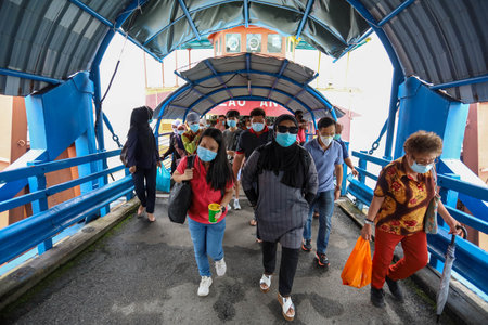 Pulau Pinang , Malaysia - Dec 19 2020: Crowd of unrecognizable local tourist wearing surgical mask for prevent coronavirus Outbreak at Butterworth ferry terminal to Penang islandのeditorial素材