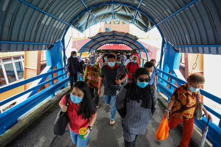 Pulau Pinang , Malaysia - Dec 19 2020: Crowd of unrecognizable local tourist wearing surgical mask for prevent coronavirus Outbreak at Butterworth ferry terminal to Penang islandのeditorial素材