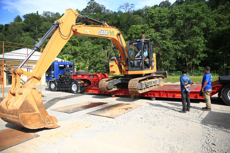 Sintok,Kedah Malaysia - Circa November 2020 : Case Excavator cx-125 uploading process on trailer trucks. The Case Corporation was a manufacturer of construction equipment and agricultural equipment.のeditorial素材