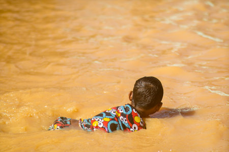 Changlun,Kedah Malaysia- Circa November 2020 : A group of kids playing on flood water 
in front of the houseのeditorial素材